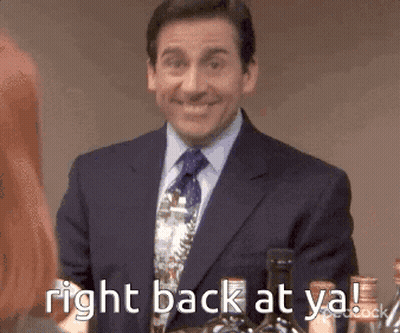 A Man In A Suit And Tie Is Smiling And Holding A Bottle Of Wine . GIF