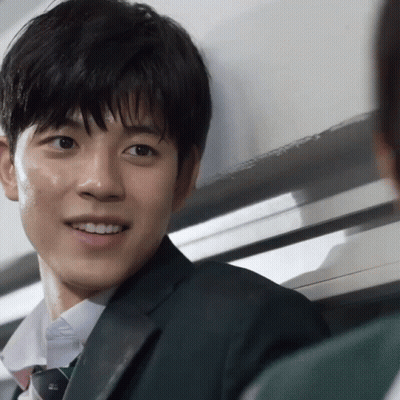 A Man In A Suit And Tie Is Smiling And Looking At The Camera GIF