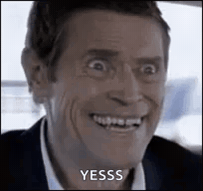 A Man In A Suit And Tie Is Smiling And Making A Funny Face While Sitting In A Car . GIF