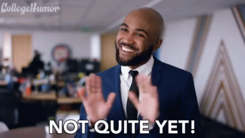 A Man In A Suit And Tie Is Smiling And Says Not Quite Yet GIF