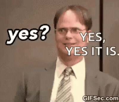 A Man In A Suit And Tie Is Smiling And Says Yes . GIF