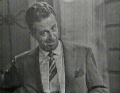 A Man In A Suit And Tie Is Smiling GIF