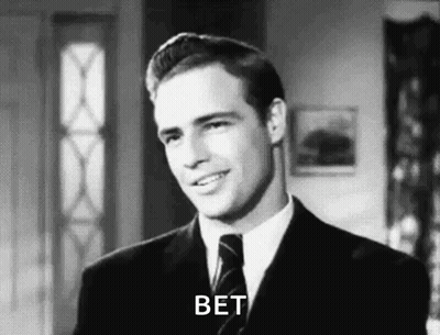 A Man In A Suit And Tie Is Smiling In A Black And White Photo And Says Bet . GIF