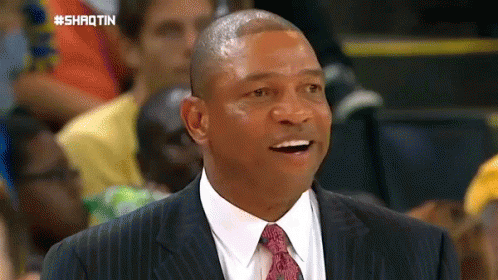 A Man In A Suit And Tie Is Smiling In Front Of A Crowd With The Hashtag #Shrotin On The Bottom GIF