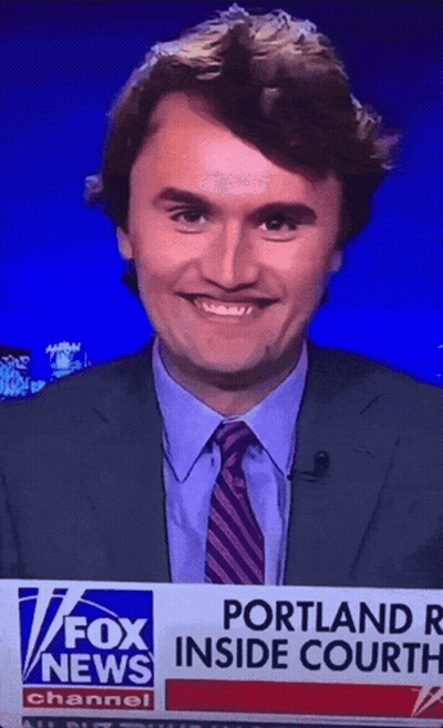 a man in a suit and tie is smiling in front of a fox news banner