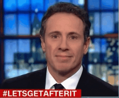 A Man In A Suit And Tie Is Smiling In Front Of A Screen That Says #Letsgetafterit GIF