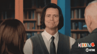 A Man In A Suit And Tie Is Smiling In Front Of A Showtime Logo GIF