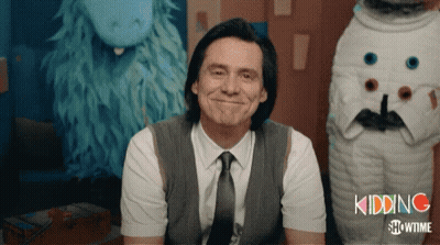 A Man In A Suit And Tie Is Smiling In Front Of A Showtime Logo GIF