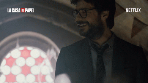 A Man In A Suit And Tie Is Smiling In Front Of A Window With The Words La Casa De Papel On The Bottom GIF