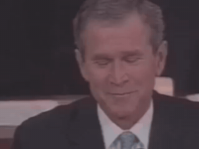 A Man In A Suit And Tie Is Smiling . GIF