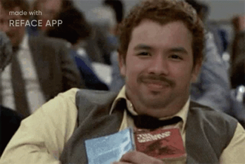 A Man In A Suit And Tie Is Smiling While Holding A Bag Of Chips That Says ' Crunch ' On It GIF
