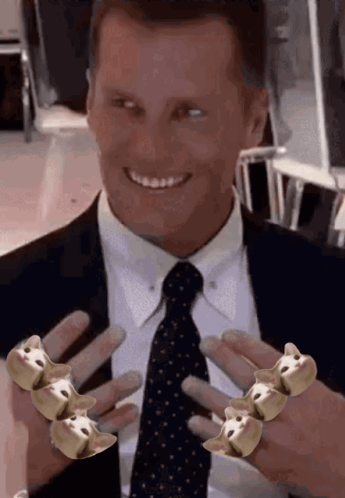 A Man In A Suit And Tie Is Smiling While Holding A Ring With A Dog Face On It GIF