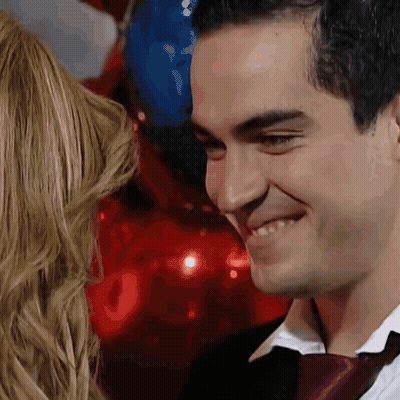 A Man In A Suit And Tie Is Smiling While Looking At A Woman GIF