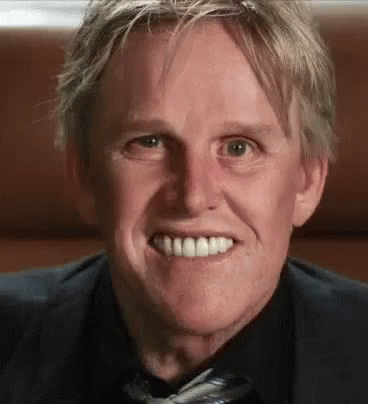 A Man In A Suit And Tie Is Smiling While Looking At The Camera . GIF