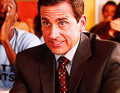 A Man In A Suit And Tie Is Smiling While Sitting At A Table With Other People GIF