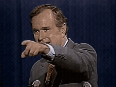 A Man In A Suit And Tie Is Smiling While Speaking Into A Microphone GIF
