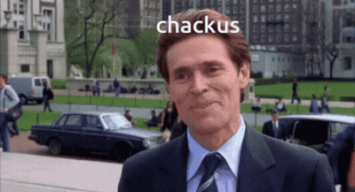 A Man In A Suit And Tie Is Smiling With The Word Chackus Behind Him GIF