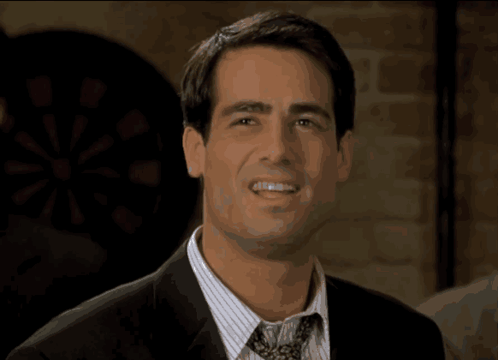 A Man In A Suit And Tie Is Smiling With The Word Prove It Behind Him GIF