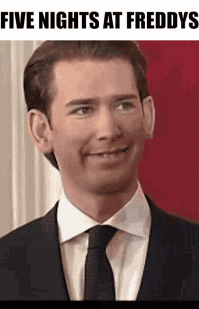 A Man In A Suit And Tie Is Smiling With The Words Five Nights At Freddys Below Him GIF