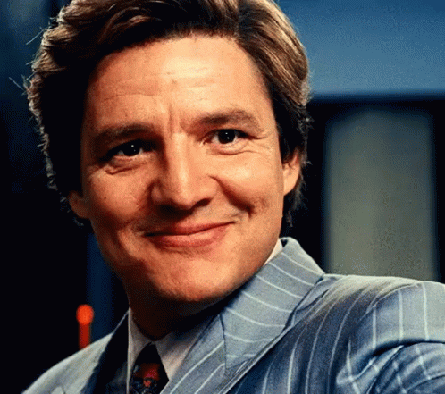A Man In A Suit And Tie Is Smiling . GIF