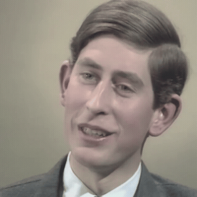 A Man In A Suit And Tie Is Smiling GIF