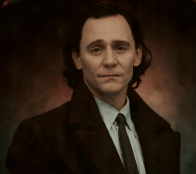 A Man In A Suit And Tie Is Smiling . GIF