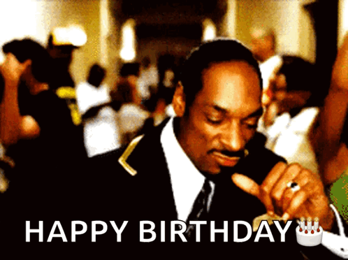 A Man In A Suit And Tie Is Smoking A Cigarette With The Words Happy Birthday Below Him GIF