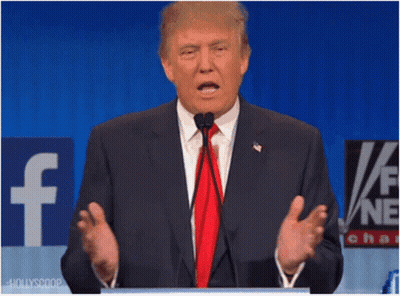 A Man In A Suit And Tie Is Speaking Into A Microphone In Front Of A Facebook Sign GIF
