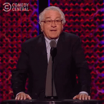 A Man In A Suit And Tie Is Standing At A Podium Giving A Speech And Saying `` Not One '' . GIF