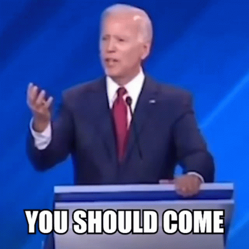 A Man In A Suit And Tie Is Standing At A Podium Giving A Speech And Says You Should Come . GIF
