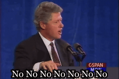 A Man In A Suit And Tie Is Standing At A Podium Talking Into A Microphone And Saying No No No No No No No GIF