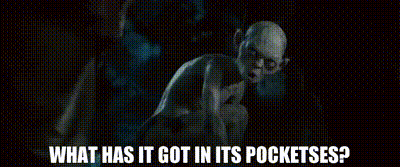 A Man In A Suit And Tie Is Standing In A Cave And Asking What Has It Got In Its Pockets ? GIF