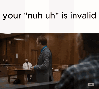 A Man In A Suit And Tie Is Standing In A Courtroom And Talking To Another Man Sitting At A Table . GIF