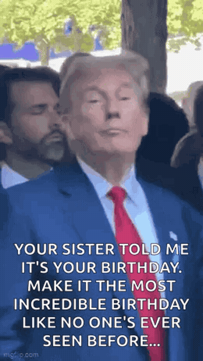 A Man In A Suit And Tie Is Standing In A Crowd . GIF