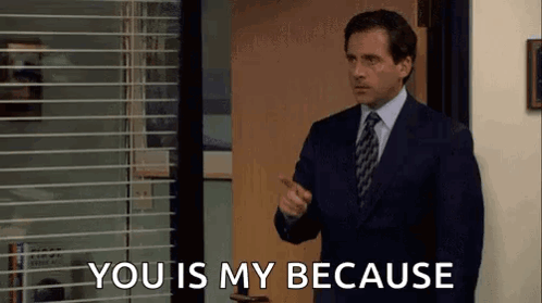 A Man In A Suit And Tie Is Standing In A Doorway And Pointing At The Camera . GIF