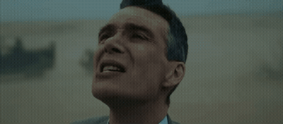 A Man In A Suit And Tie Is Standing In A Field . GIF