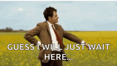 A Man In A Suit And Tie Is Standing In A Field Of Yellow Flowers And Says `` Guess I Will Just Wait Here ... '' GIF