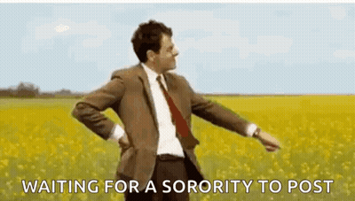A Man In A Suit And Tie Is Standing In A Field Of Yellow Flowers And Waiting For A Sorority To Post . GIF