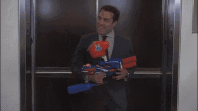A Man In A Suit And Tie Is Standing In A Hallway Holding A Folder GIF