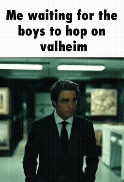A Man In A Suit And Tie Is Standing In A Hallway With The Caption " Me Waiting For The Boys To Hop On Valheim " GIF