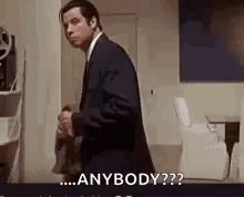 A Man In A Suit And Tie Is Standing In A Room And Says `` Anybody ? '' GIF