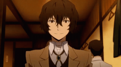 A Man In A Suit And Tie Is Standing In A Room With Other Men . GIF