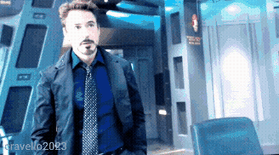 A Man In A Suit And Tie Is Standing In A Room With The Name Gravello2023 In The Corner GIF