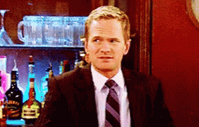 A Man In A Suit And Tie Is Standing In Front Of A Bar Full Of Bottles GIF