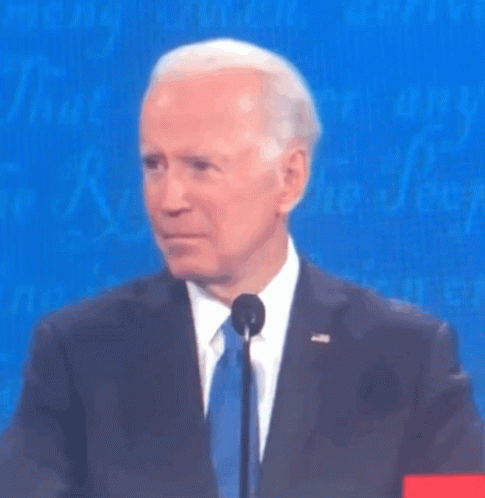 A Man In A Suit And Tie Is Standing In Front Of A Blue Background GIF