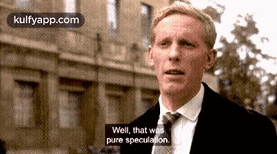 A Man In A Suit And Tie Is Standing In Front Of A Building And Says Well , That Was Pure Speculation . GIF