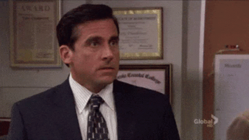 A Man In A Suit And Tie Is Standing In Front Of A Bulletin Board That Says Award On It GIF
