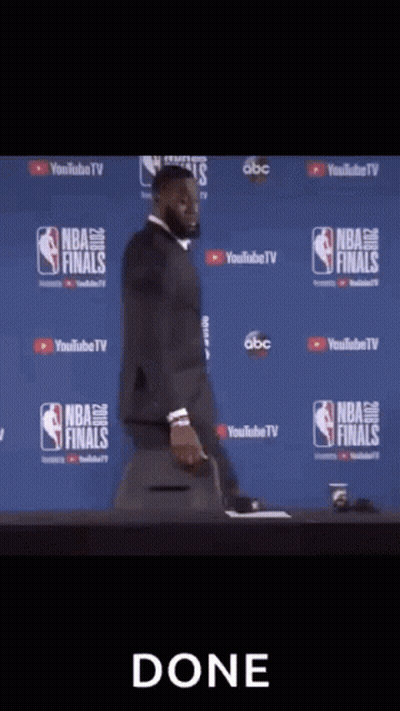 A Man In A Suit And Tie Is Standing In Front Of A Camera With The Word Done On The Bottom GIF