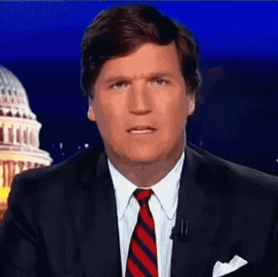 A Man In A Suit And Tie Is Standing In Front Of A Capitol Building . GIF