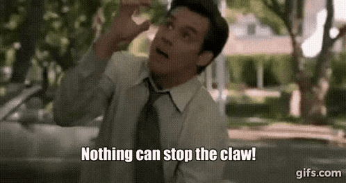 A Man In A Suit And Tie Is Standing In Front Of A Car And Says Nothing Can Stop The Claw . GIF